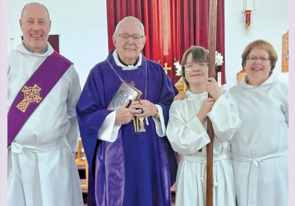 The image shows four people in a church. Two individuals are wearing white robes, one with a purple stole, while another wears a purple robe and holds a book with a cross.